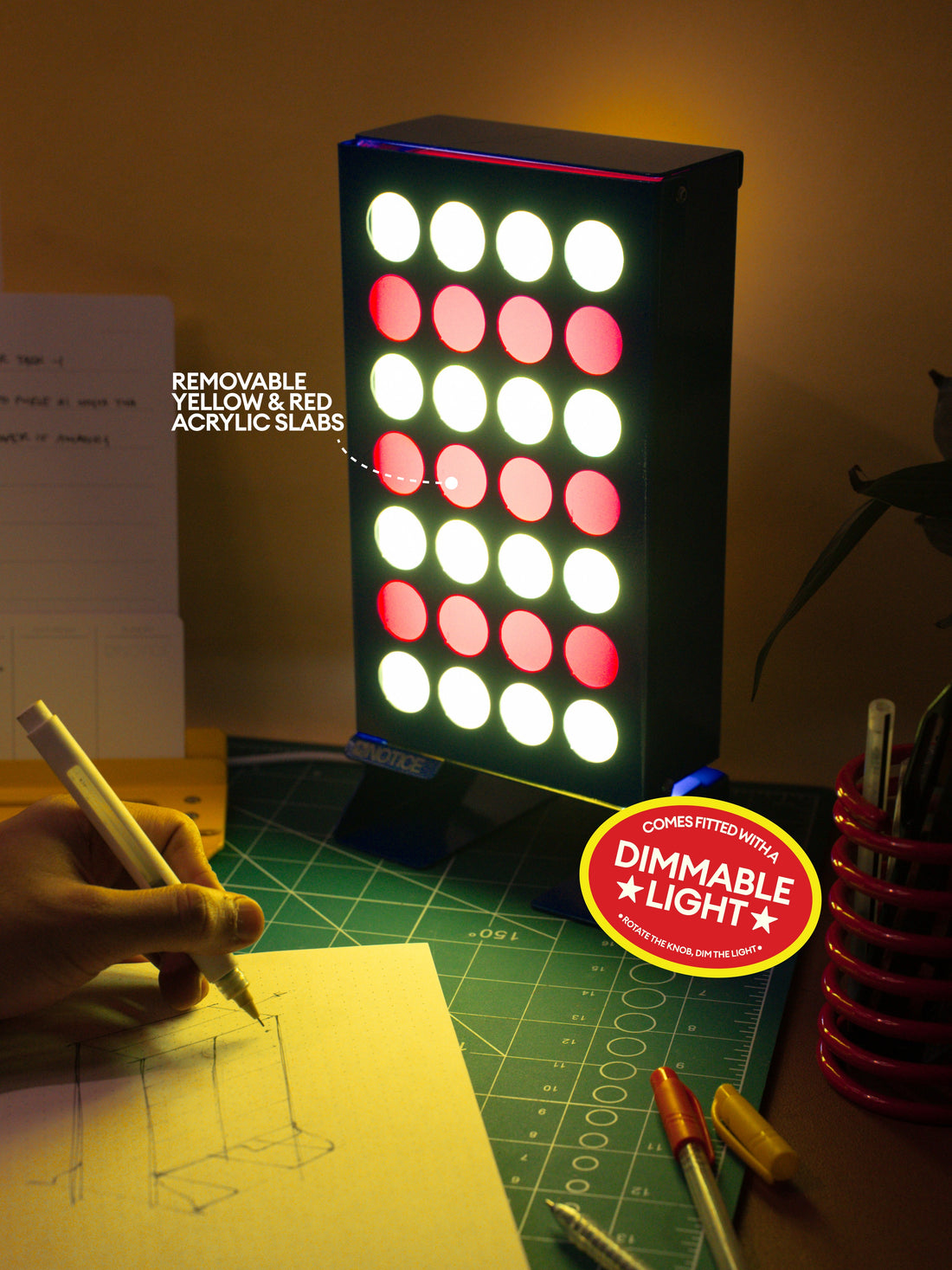Stack 4 Lamp on a work desk with removable yellow and red acrylic slabs and a dimmable light